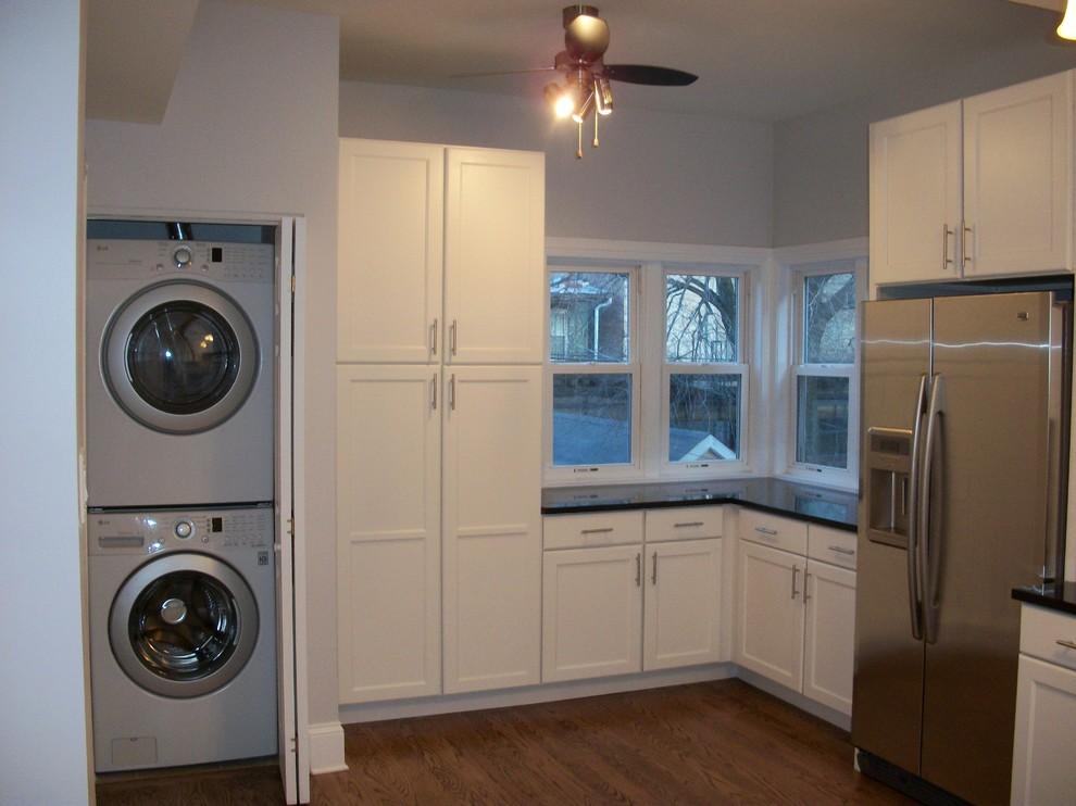 custom white cabinetry in kitchen with washer and dryer