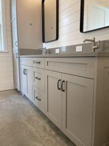 Semi Custom Bath Vanity With Grey Quartz Top, White Shaker Cabinetry With Flush Faces, Upper Horizontal Ship Lap And Concrete Floor.