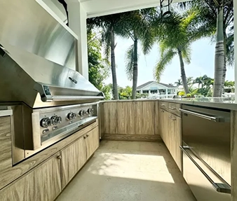 outdoor kitchen with semi custom cabinetry and palm trees in backgroun